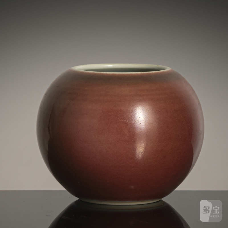 A copper-red spherical porcelain brush washer